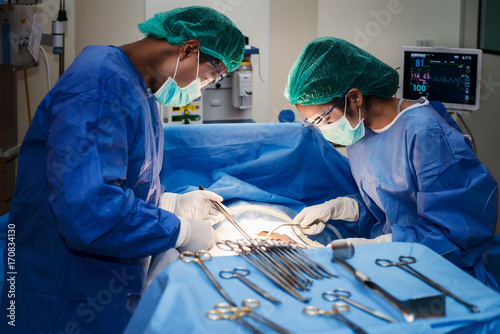 Asian doctor and an assistant in the operating room for surgical venous vascular surgery clinic in hospital. photo