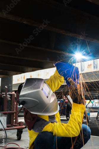 Industry worker with welding steel to repair container structures manufacture workshop in factory industry.
