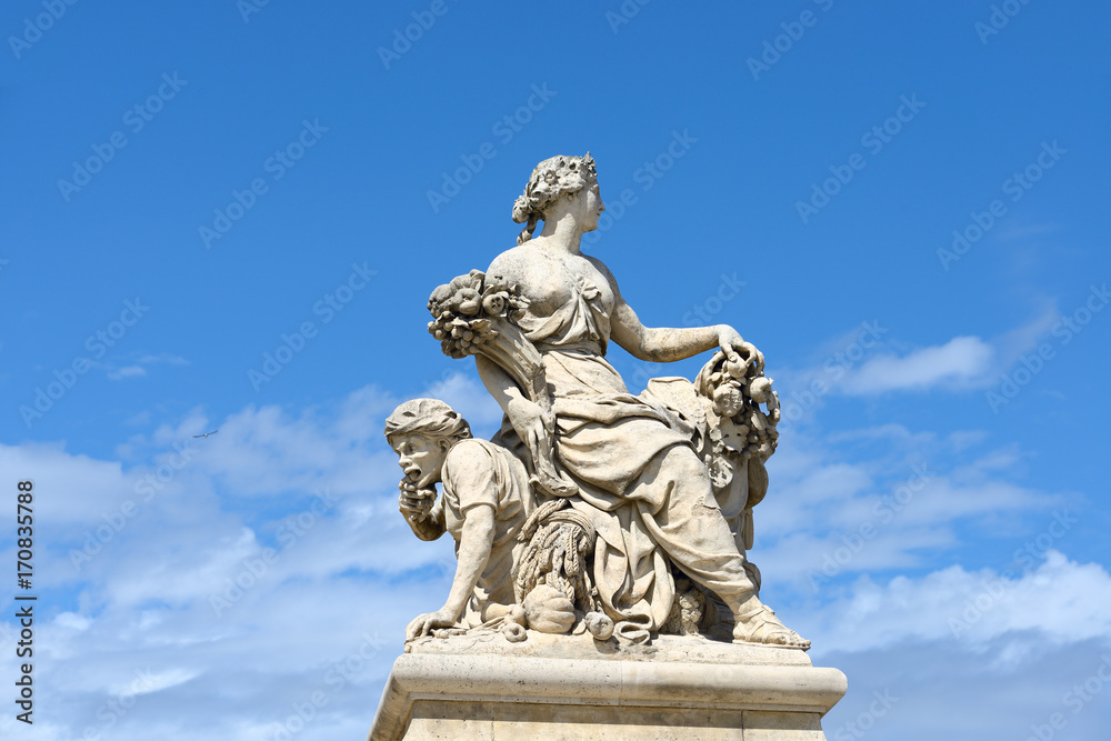 Statues over blue sky at the Palace of Versailles, France.