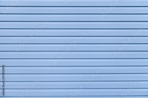 Blue vinyl wooden siding panel background with imitation wood texture.