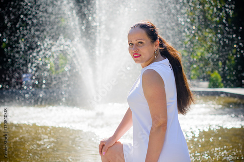 A mature active sinple woman from small town walks in the city park on a warm day and enjoys life. A lady without complexes feeling sexy and loves herself and her appearance