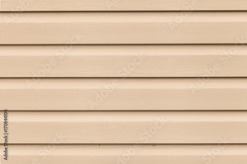 Photo Close up Light brown (beige) vinyl wooden siding panel background with imitation wood texture