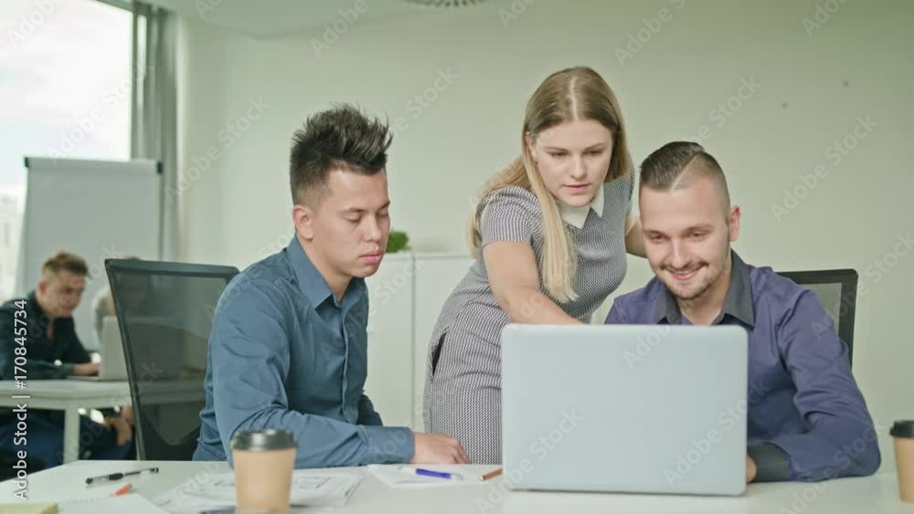 Creative business team meeting in modern start up office female team leader pointing at screen discussing diverse people group teamwork using laptop display Creative business team meeting in modern start up office female team leader pointing at screen discussing diverse people group teamwork using laptop display