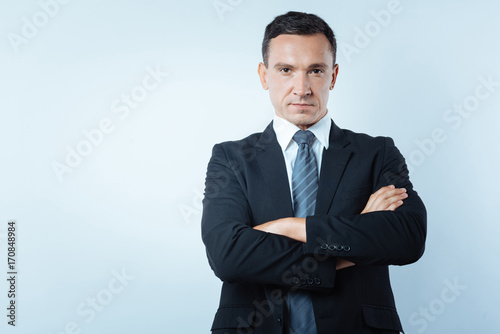 Serious confident man standing cross armed