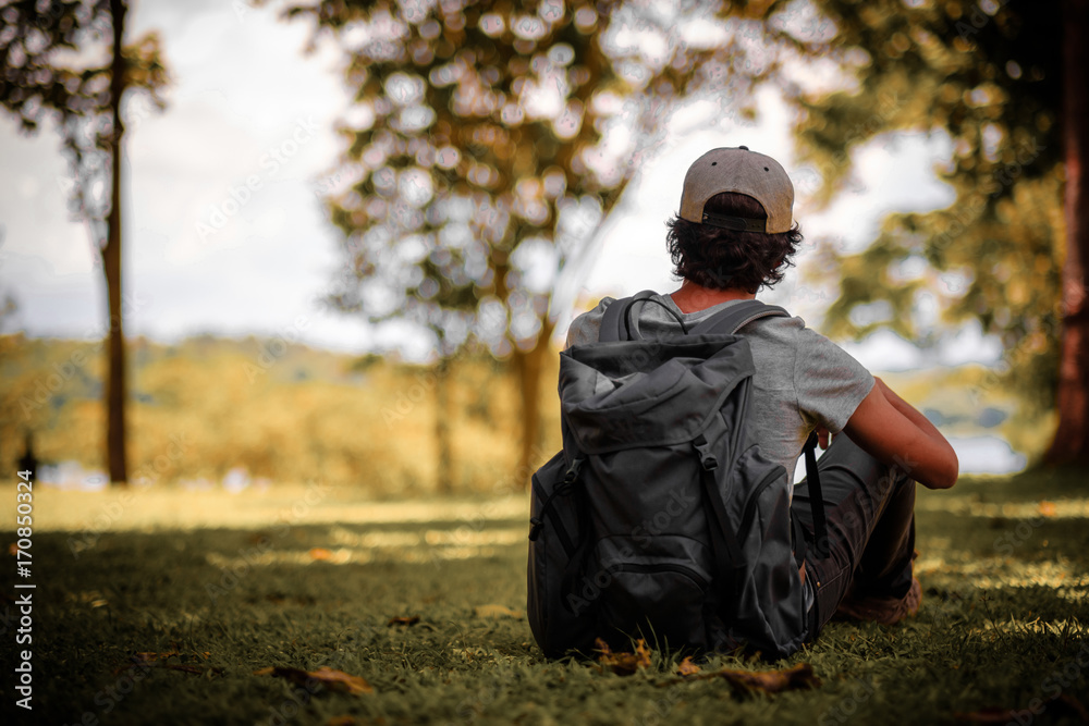 man traveling walking with backpack at national park in the jungle day time sun shine on holiday at weekend relax fresh on background nature view