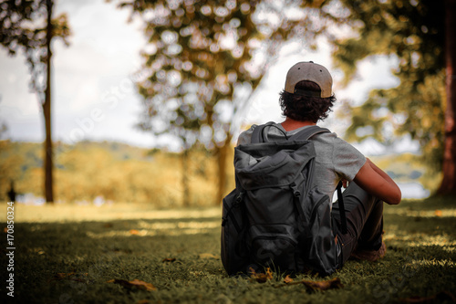 man traveling walking with backpack at national park in the jungle day time sun shine on holiday at weekend relax fresh on background nature view