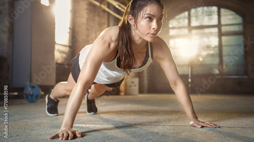 Athletic Beautiful Woman Does Push-ups as Part of Her Cross Fitness, Bodybuilding Gym Training Routine.