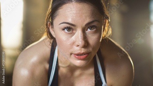 Fototapeta Naklejka Na Ścianę i Meble -  Shot of a Beautiful Athletic Brunette Resting on the Bench and Smiling into the Camera.