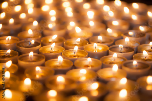 Soft dreamy image of bright candlelight from burning tea light candles. Christmas background image.