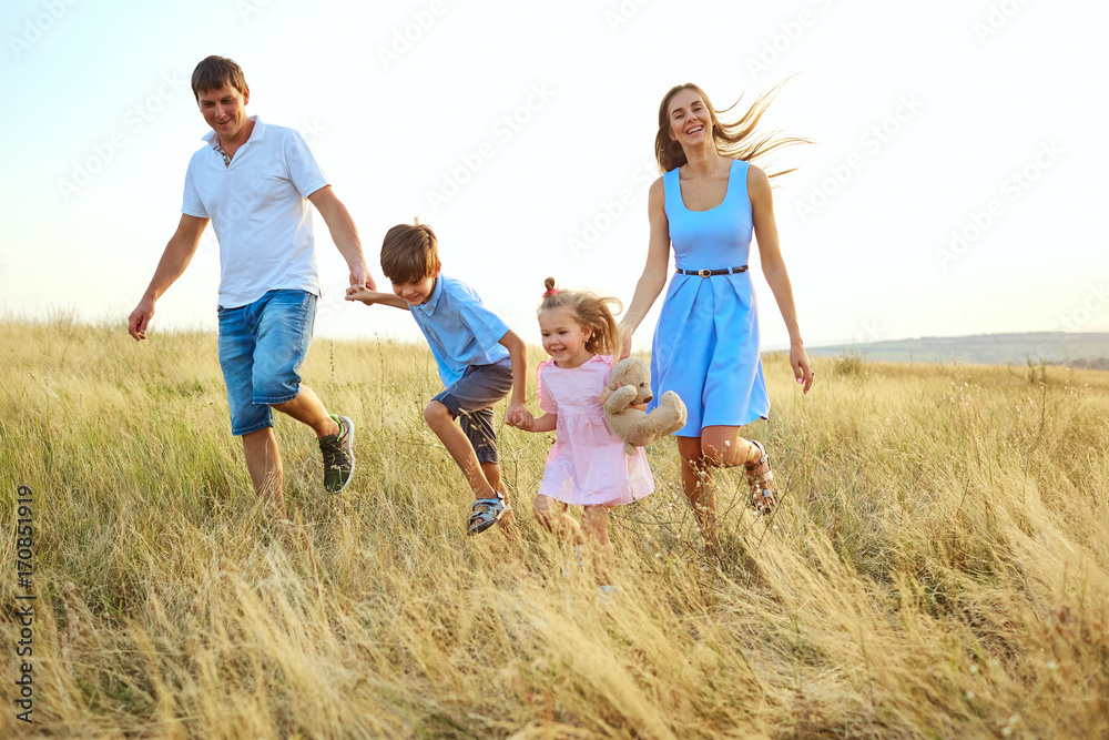 Happy family outdoors walking and smiling in the summer autumn.