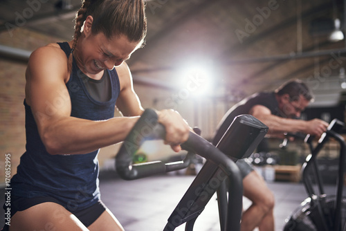 Obraz na plátně Sportsmen working out hard on cycling machines