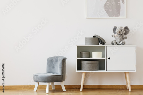 Grey chair next to white shelf