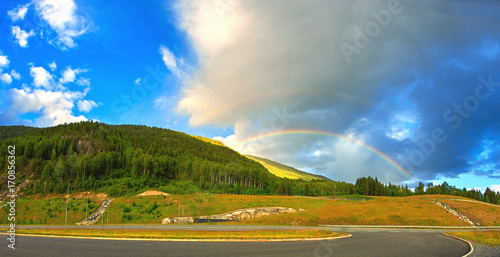 Double rainbow over green forest in summer