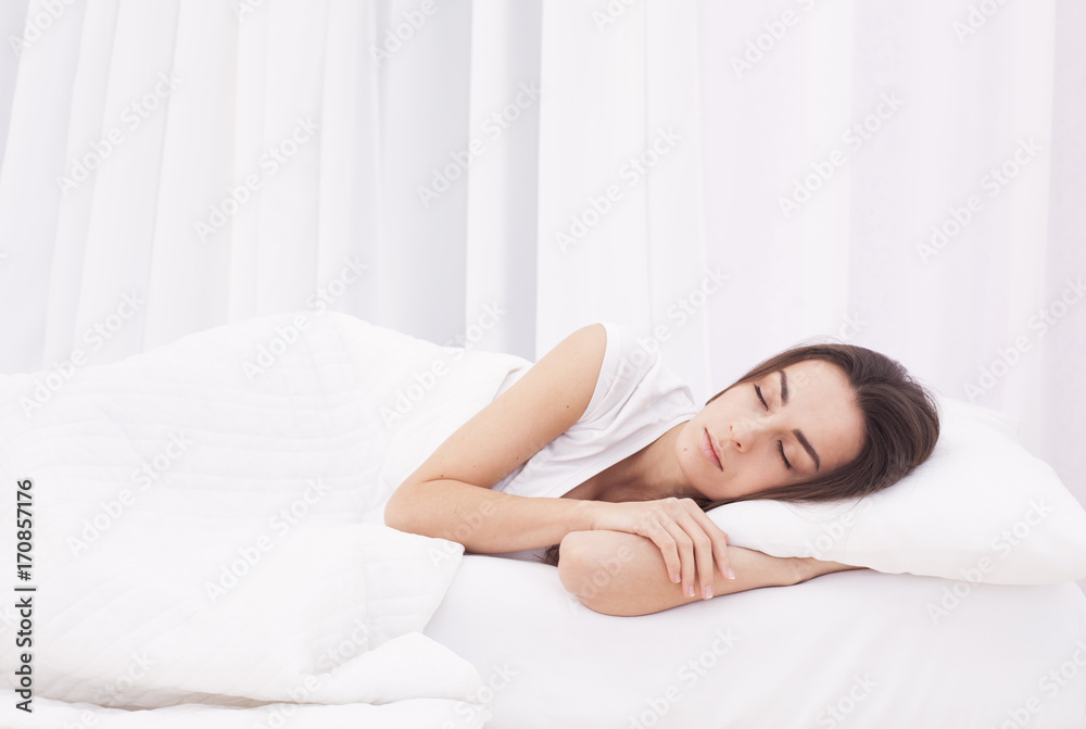 Beautiful young brunette woman sleeping in a white bed. Beautiful young brunette woman sleeping in a white bed.