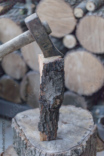 Axe with hand, Heap of chopped wood, close up on the axe, cutting firewood and preparing winter wood