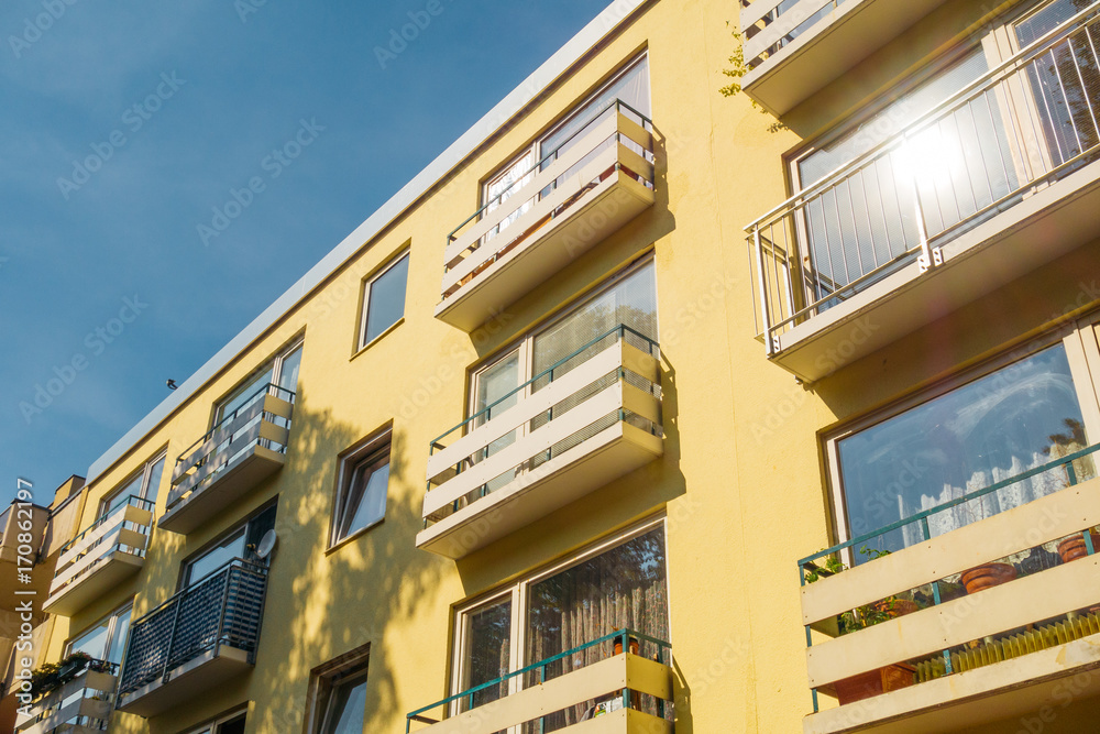 yellow apartment complex with white balcony