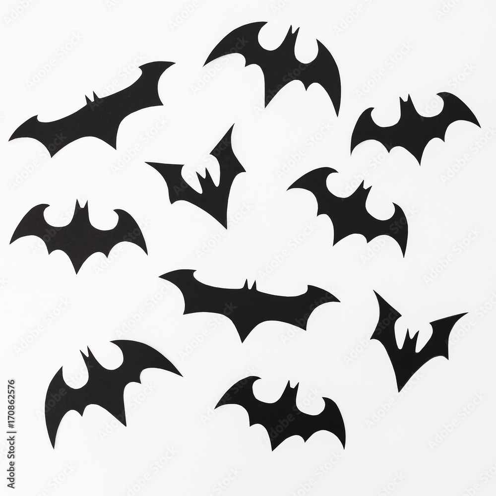 Halloween pattern made of handmade black paper bats for Halloween holiday on white background. Flat lay, top view. Halloween pattern made of handmade black paper bats for Halloween holiday on white background. Flat lay, top view.
