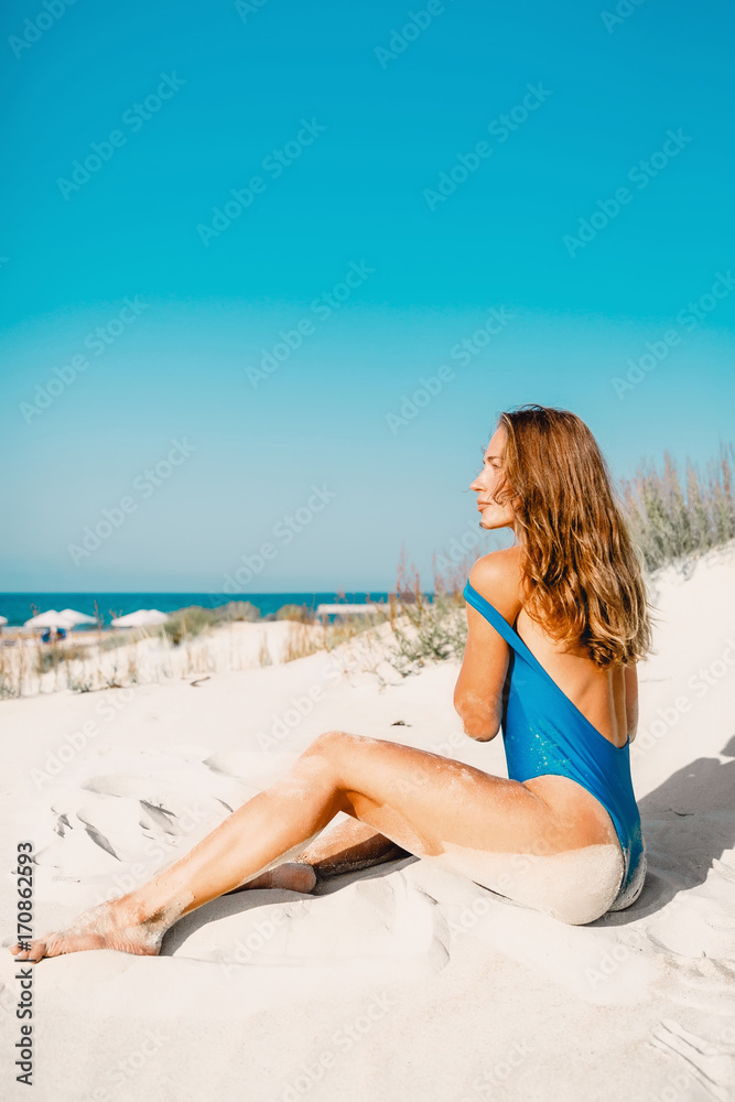Young woman in swimwear with sand on tropical beach. Summer woman body Young woman in swimwear with sand on tropical beach. Summer woman body