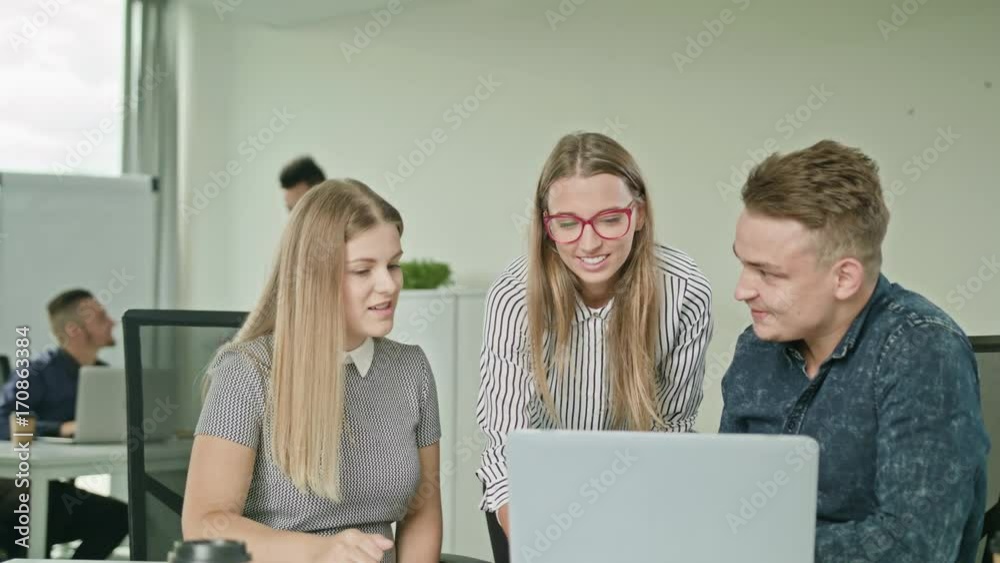Creative business team meeting in modern start up office female team leader pointing at screen discussing diverse people group teamwork using laptop display