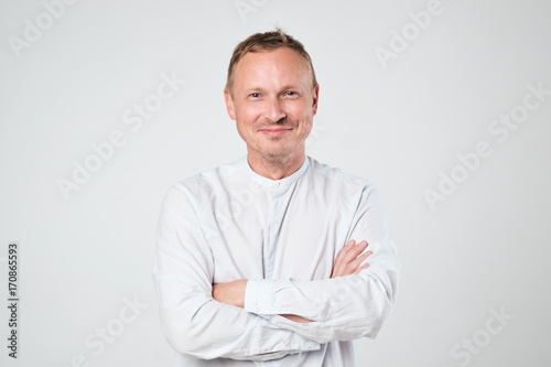 Smiling young man in black clothesstanding against white background © Viktor Koldunov