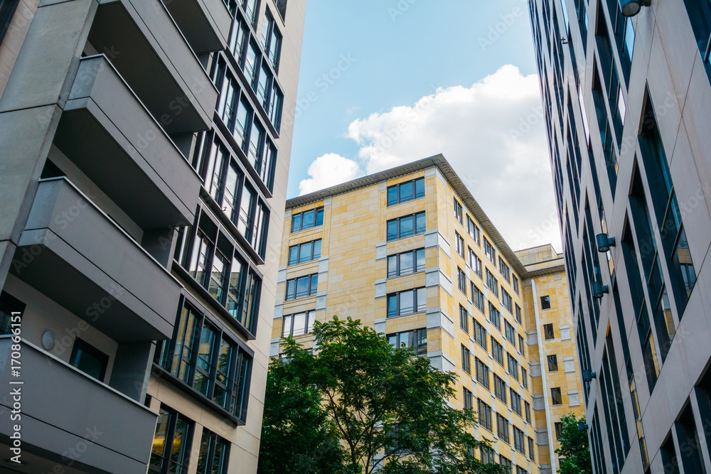 Fototapeta premium yellow apartment house between two big buildings