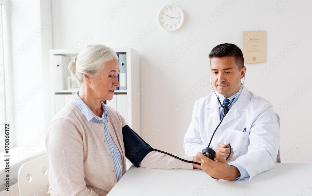 Fototapeta premium senior woman and doctor with tonometer at hospital