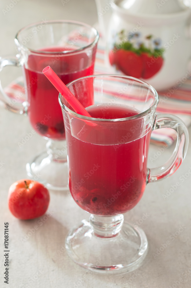 Fresh berry drink in a glass cup on a white table. Selective focus Fresh berry drink in a glass cup on a white table. Selective focus