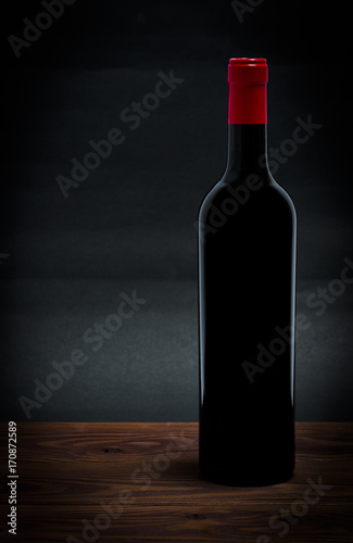 Bottle of red wine on a dark grey background