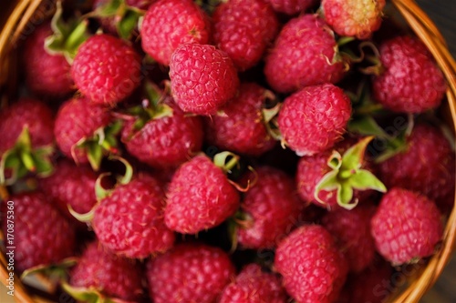 Delicious juicy raspberry in a wooden basket