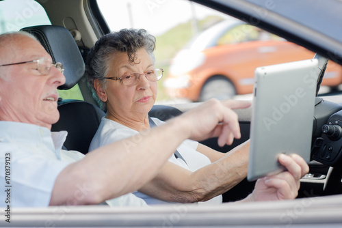old couple lovers using tablet in the car travel