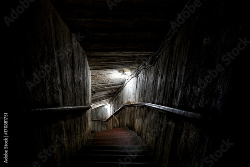 Stairs going into a dark tunnel photo