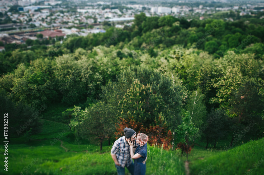 traveler couple in casual clothes gently hugging while standing near tree