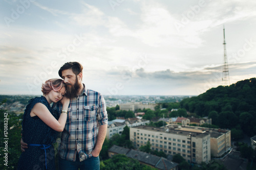 traveler couple in casual clothes gently hugging while standing on mountain