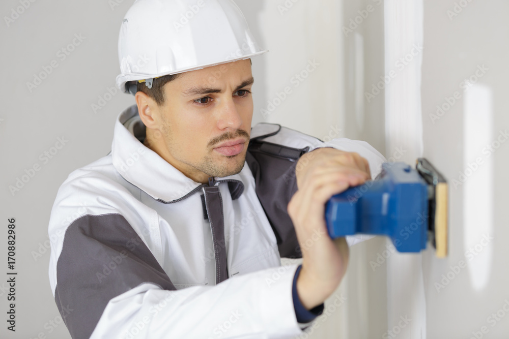 man with sanding machine in clothing construction man with sanding machine in clothing construction