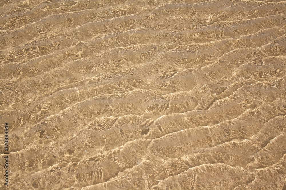 the ripples on the water and sand on the bottom