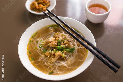 Foto Dish of Burmese Shan noodles soup on a table with chopsticks in Myanmar, viewed from slightly above