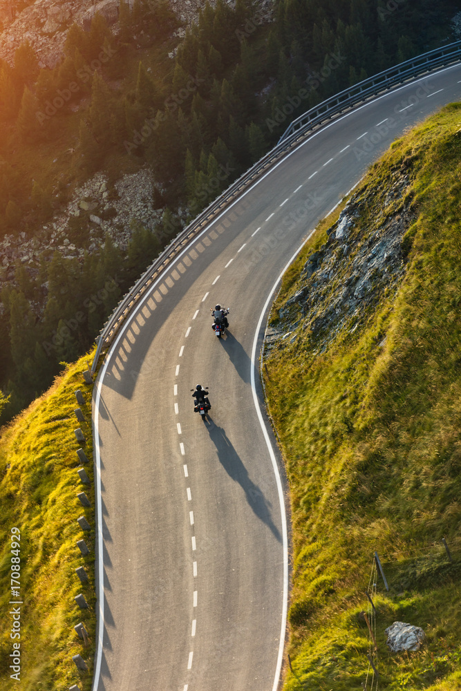 Obraz premium Kierowcy motocykli jadący autostradą alpejską. Fotografia plenerowa