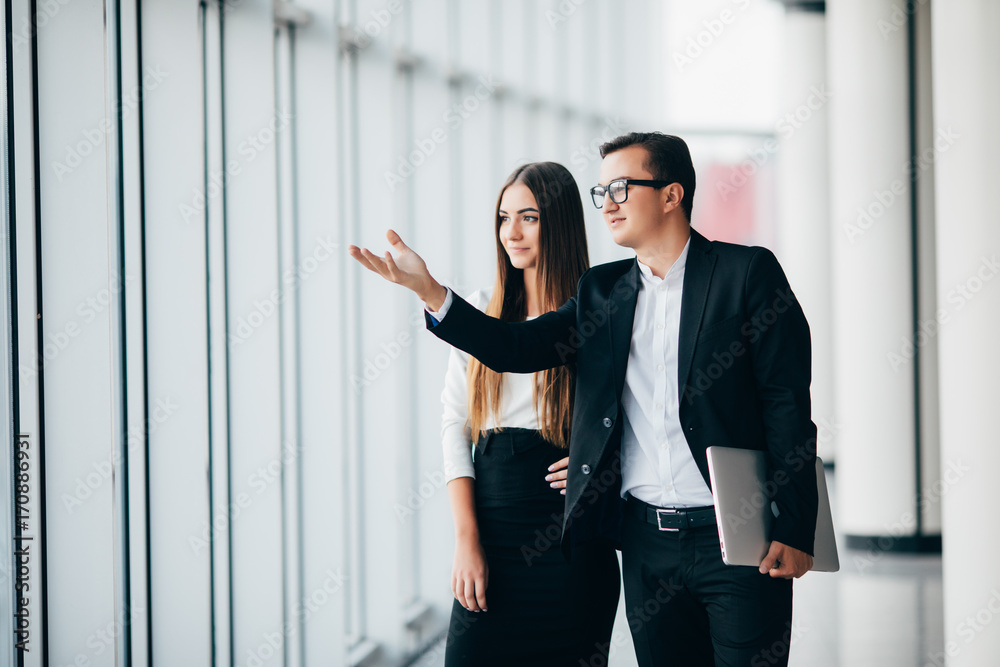 business man and business woman discusing future plans and working with new start up project in modern office in panoramic windows business man and business woman discusing future plans and working with new start up project in modern office in panoramic windows