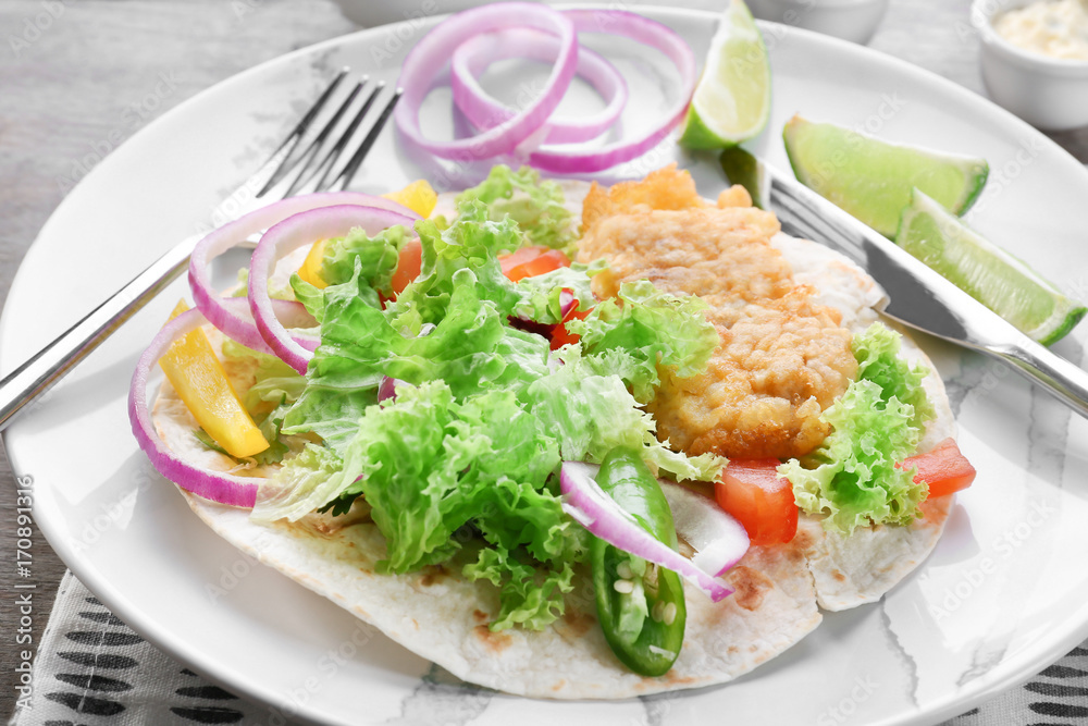 Plate with delicious fish taco on table Plate with delicious fish taco on table