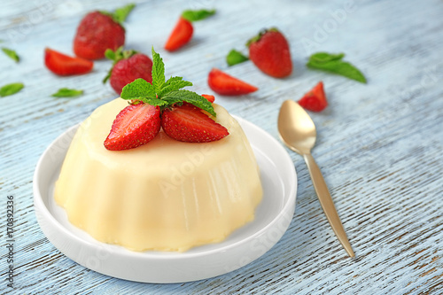 Plate with delicious vanilla pudding on table photo