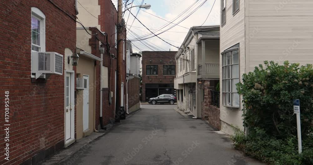 A daytime establishing shot of an empty alleyway in a small town in America. A daytime establishing shot of an empty alleyway in a small town in America.