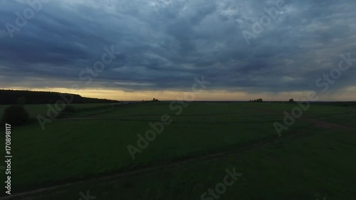 View from drone field with sunset sky nature landscape background. Footage. Aerial view of rural area with forest road in summer sunset photo