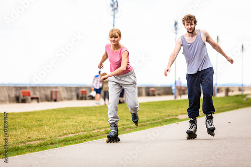 Active young people friends rollerskating outdoor.