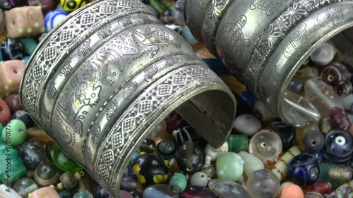 Ancient indian bracelet armlet rotating on old beads background