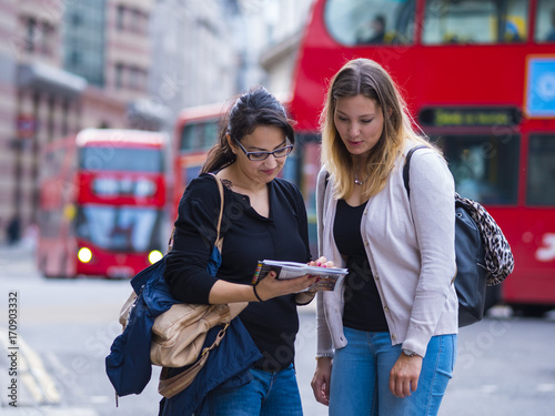 Canvas Print Two girls read a map in the city center of London