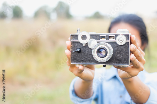 Woman photographed in a meadow with a camera.