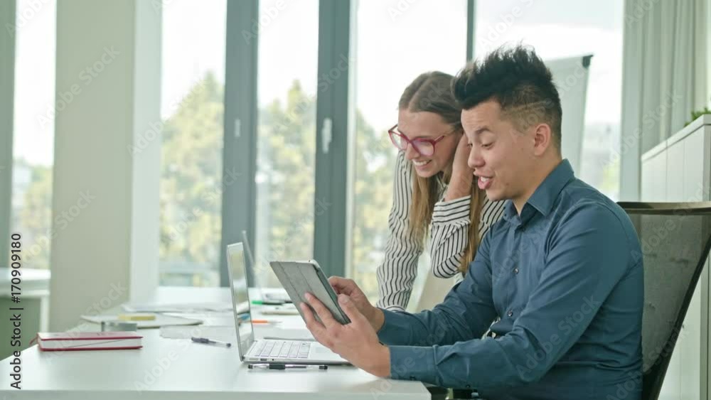 Two attractive people mixed ethnicity discussing ideas using digital tablet Two attractive people mixed ethnicity discussing ideas using digital tablet