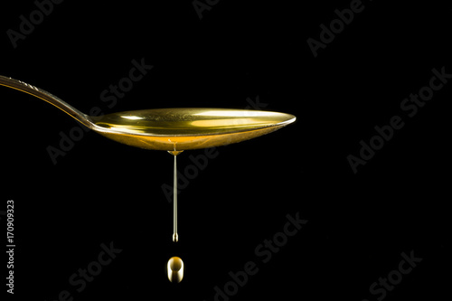 Spoonful of oil on the black background