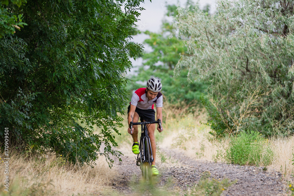Biycle rider on cyclocross bike training outdoor on gravel country road Biycle rider on cyclocross bike training outdoor on gravel country road