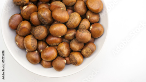 Chestnuts in a white bowl on a white background.